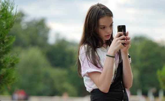 Looking intently at a phone.