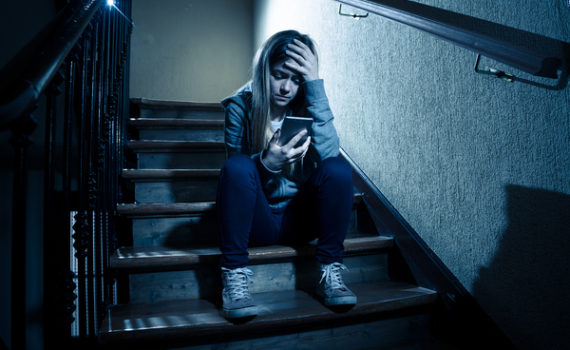 Teen sitting on steps.