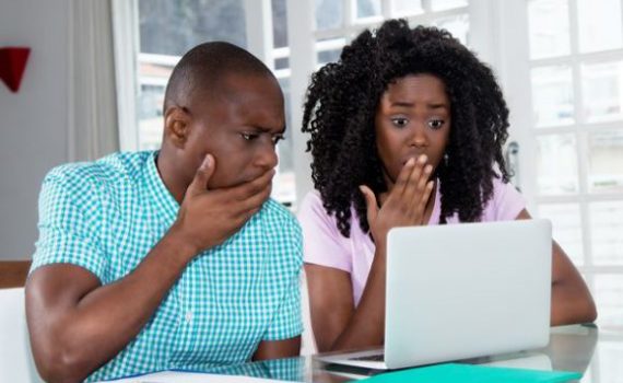 Parents looking at computer appearing surprised
