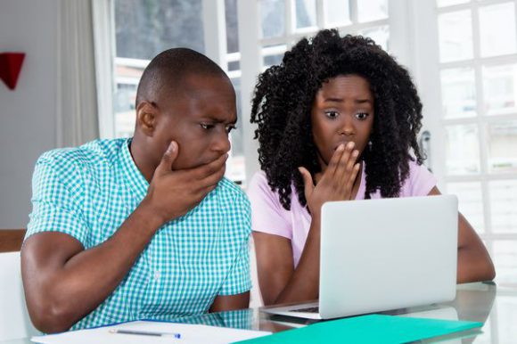 Parents looking at computer appearing surprised