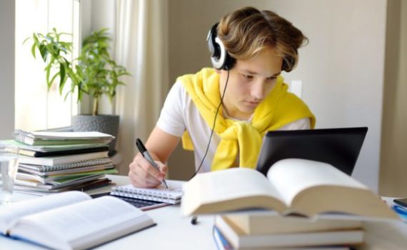 Teen wearing headphones in front of a computer