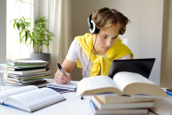 Teen wearing headphones in front of a computer